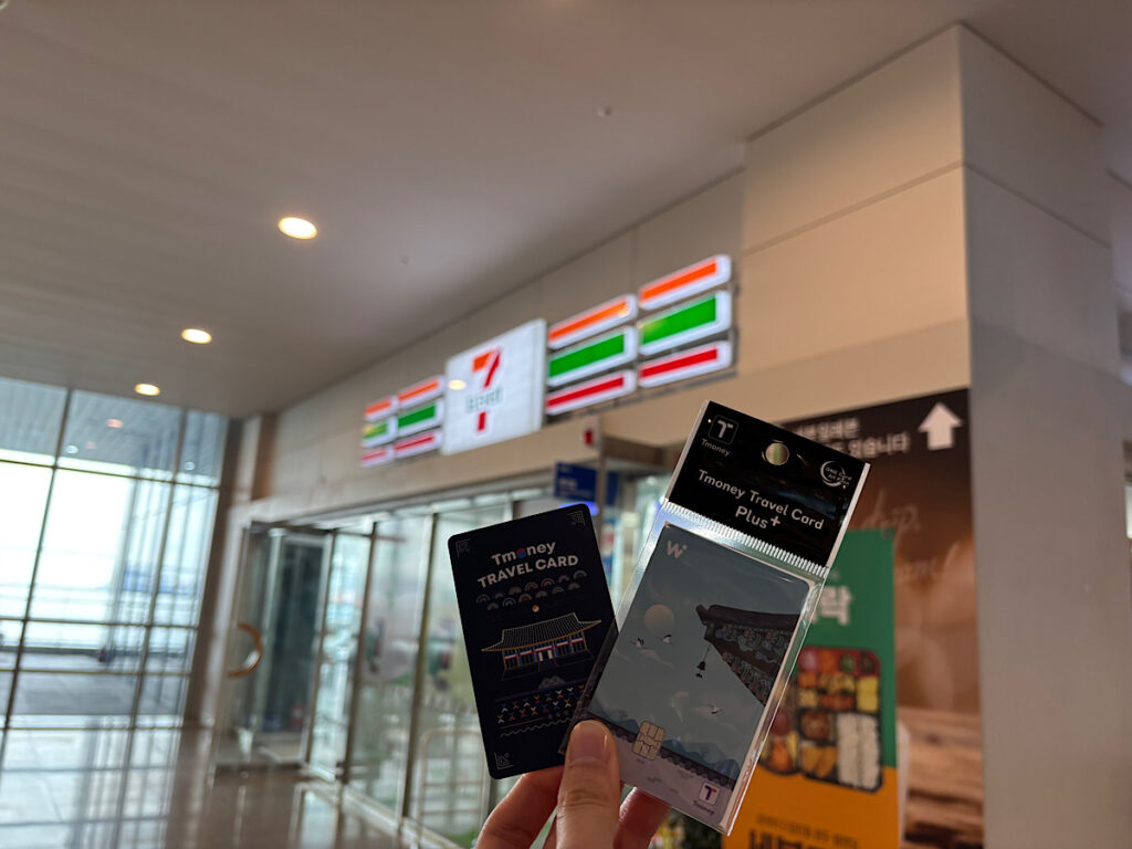 セブンイレブンを背景に２枚のT-moneyカードを写した写真