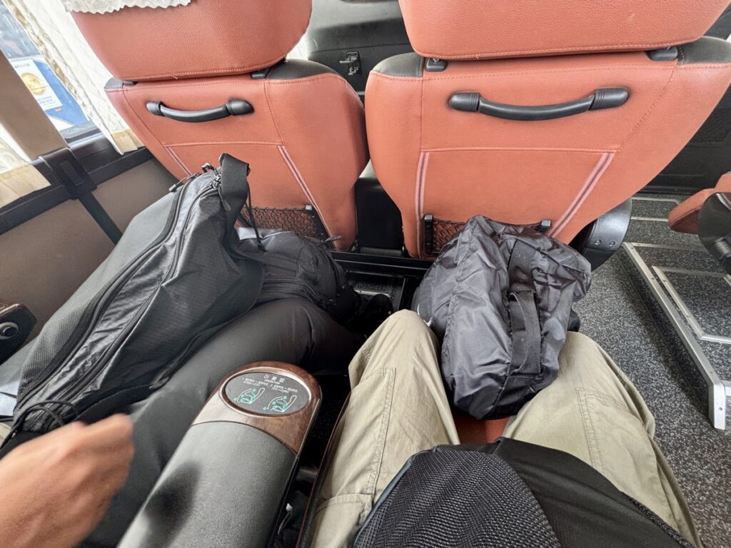 私たちがバスに着席した時の写真。足の間に大きな荷物を置いている。