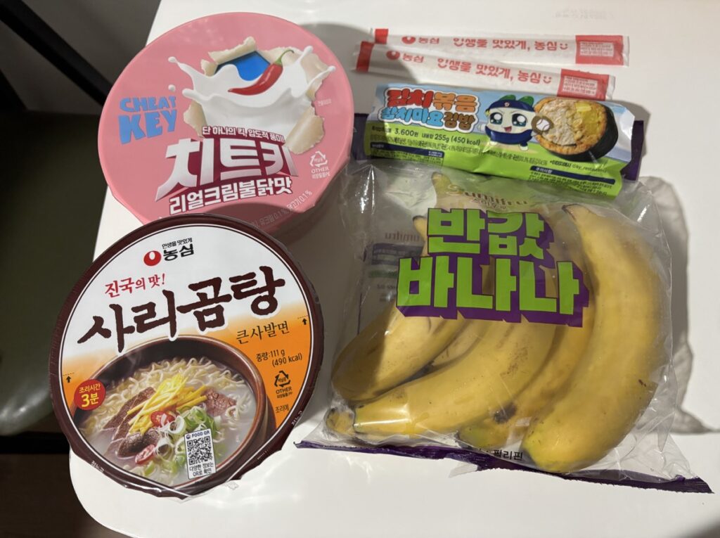カップ麺2つ、キンパ、バナナを写した写真